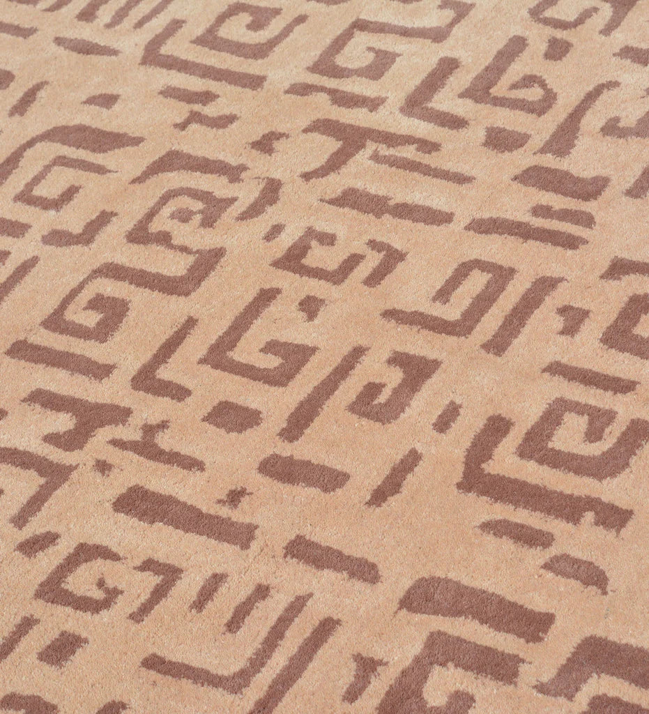 Modern wool rug with repeating brown tribal motifs on beige base