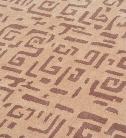 Modern wool rug with repeating brown tribal motifs on beige base