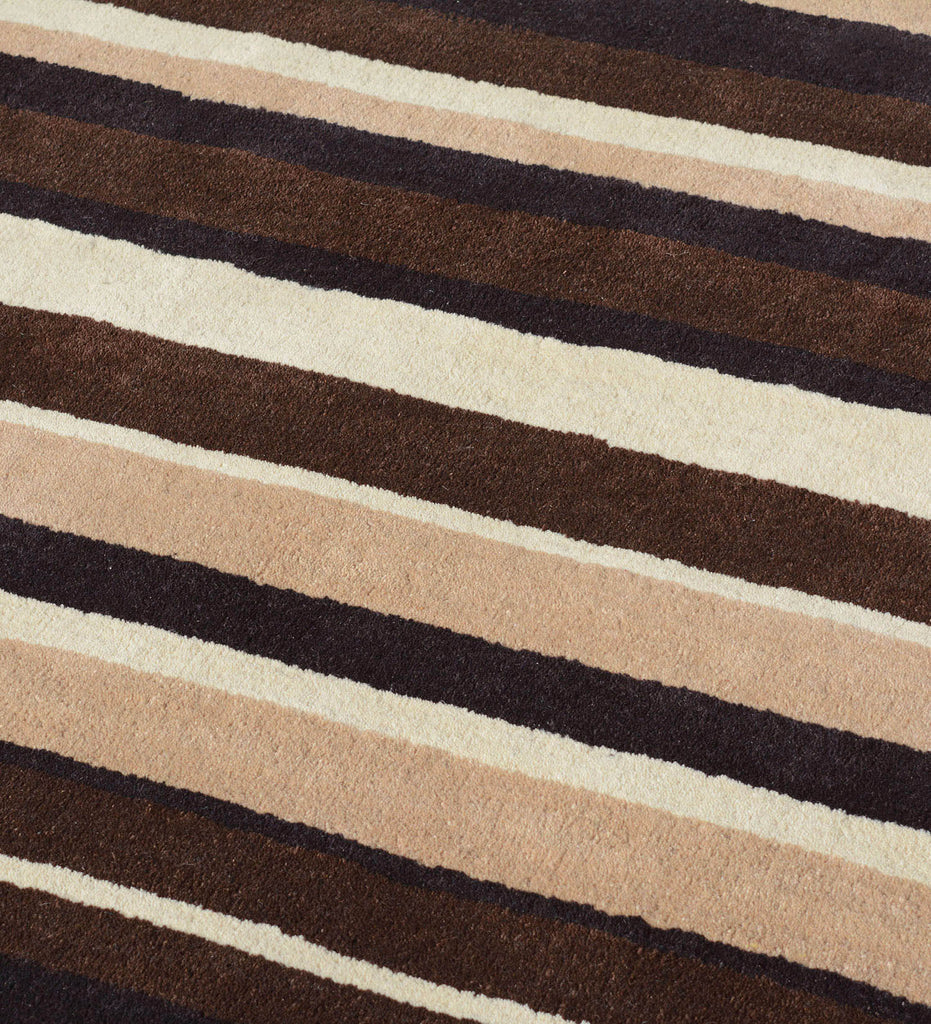 Modern hand-tufted area rug in beige, brown, and ivory tones.