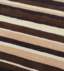 Modern hand-tufted area rug in beige, brown, and ivory tones.