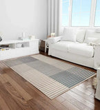 Beige and grey ombre striped rug on wooden floor in bright living room with white sofa and console