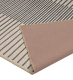 Beige and grey striped luxury rug with a folded corner revealing a beige textured backing