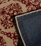Beige and red damask ornate patterned rug with visible corner showing dark woven backing