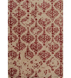 Beige rug with ornate red damask pattern featuring symmetrical floral and scroll motifs