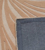 Close-up of beige and red earthy abstract patterned rug corner with dark blue textured backing