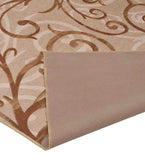 Beige tan transitional area rug with swirling floral pattern and a folded corner showing the backing