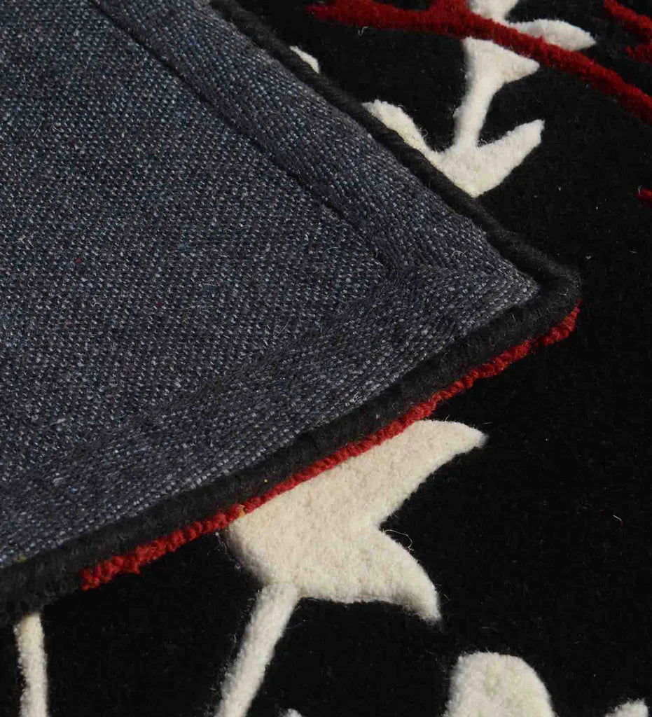 Black bold base hand tufted rug with red and white floral pattern