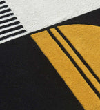 Close-up of a luxury handwoven rug with black, white, and mustard yellow geometric abstract patterns