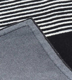 Close-up of luxury black and white striped handwoven rug corner with grey fabric backing