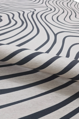 Machine washable modern rug with fluid wavy line design.
