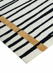 Minimalist striped rug with golden accent for modern living room decor.