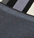 Close-up of black and gray hand-tufted runner rug with striped pattern and woven backing