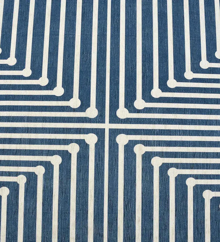 Low-profile blue rug with navy and white geometric accents.