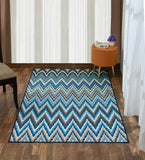 Blue pixelated chevron rug on wooden floor in modern room with orange ottoman and light curtains