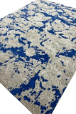 Abstract wool rug with blue, beige, and gray pixelated pattern