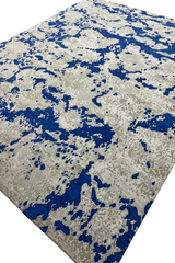 Abstract handwoven wool rug in blue and grey-beige tones.