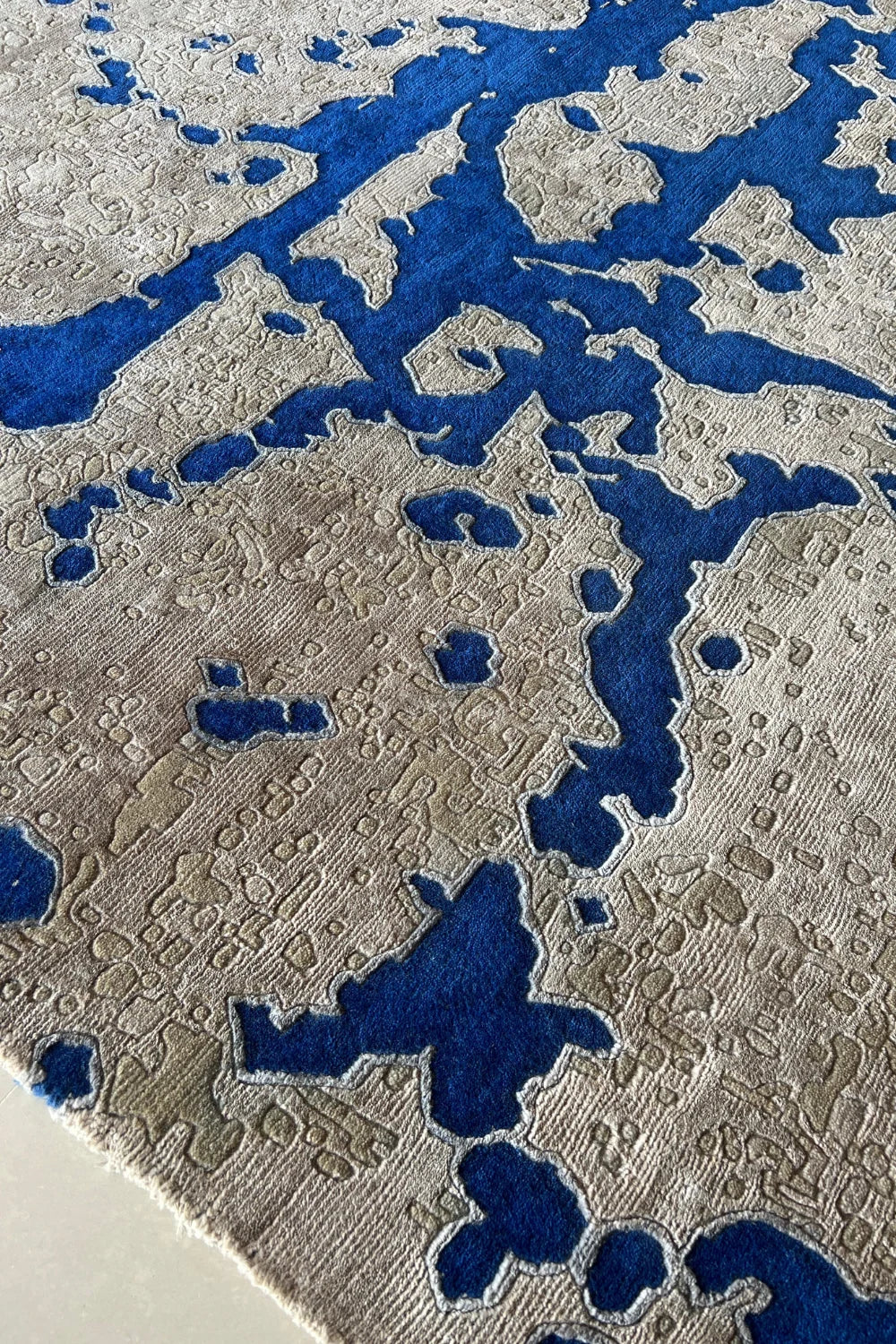 Blue and beige contemporary rug featuring abstract geometric effect.