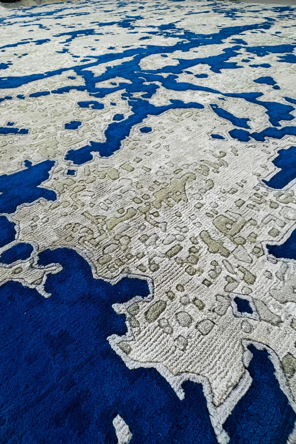 Modern hand-knotted rug in blue and beige with digital-inspired pattern.