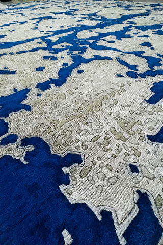Modern hand-knotted rug in blue and beige with digital-inspired pattern.
