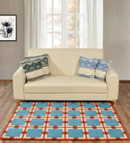 Modern beige sofa with patterned blue and green cushions on a retro grid rug in living room