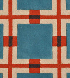 Close-up of blue, red, cream, and black geometric retro grid pattern on textured rug