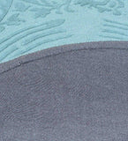 Close-up of a blue traditional hand-tufted round rug showing detailed textured patterns and fabric edge