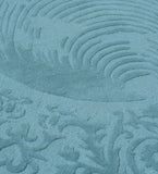 Close-up of blue traditional hand-tufted round rug with intricate textured pattern