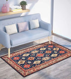 Boho traditional rug with floral and geometric patterns in navy, red, and cream under light blue sofa with cushions in modern living room