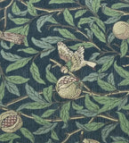 Luxury handwoven rug with botanical design featuring green leaves, branches, pomegranates, and a bird on dark blue background