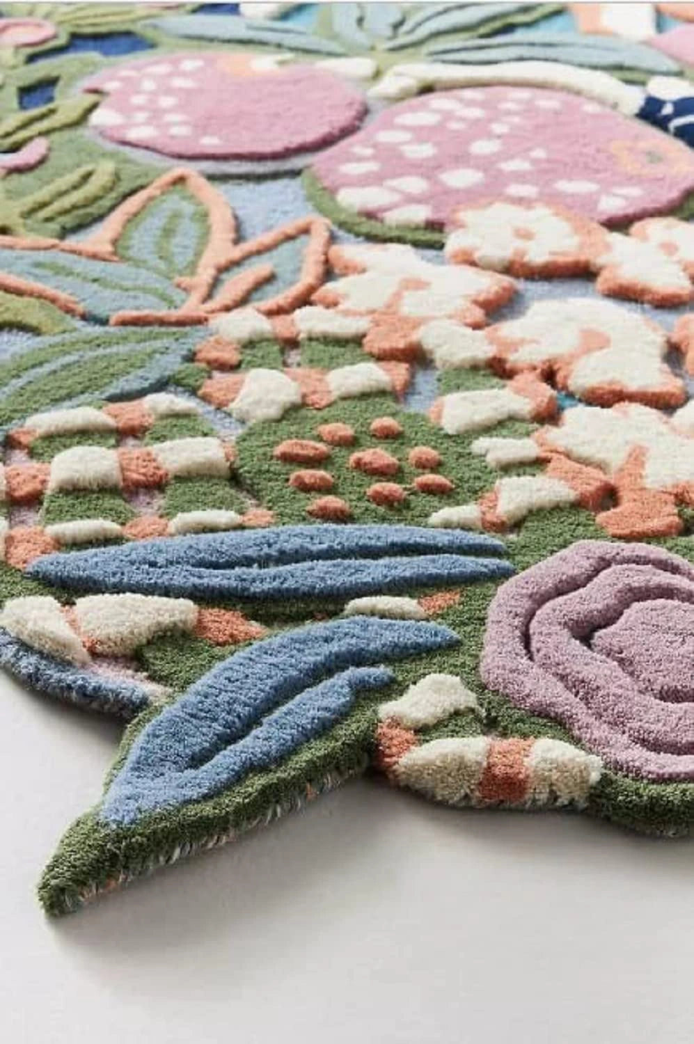 Colorful floral rug with pink flowers and green leaves on a white background