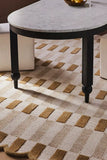Handwoven brown checkered rug under a round marble table with black legs in a modern living room