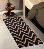 Brown and cream chevron hand tufted wool rug beside bed and small table with basket in modern bedroom
