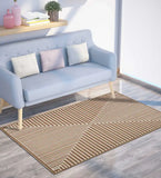 Modern living room with light blue sofa, decorative pillows, and a brown geometric patterned rug on wooden floor