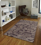 Modern living room with brown and beige abstract textured area rug on wooden floor, leather swivel chair and white shelving unit