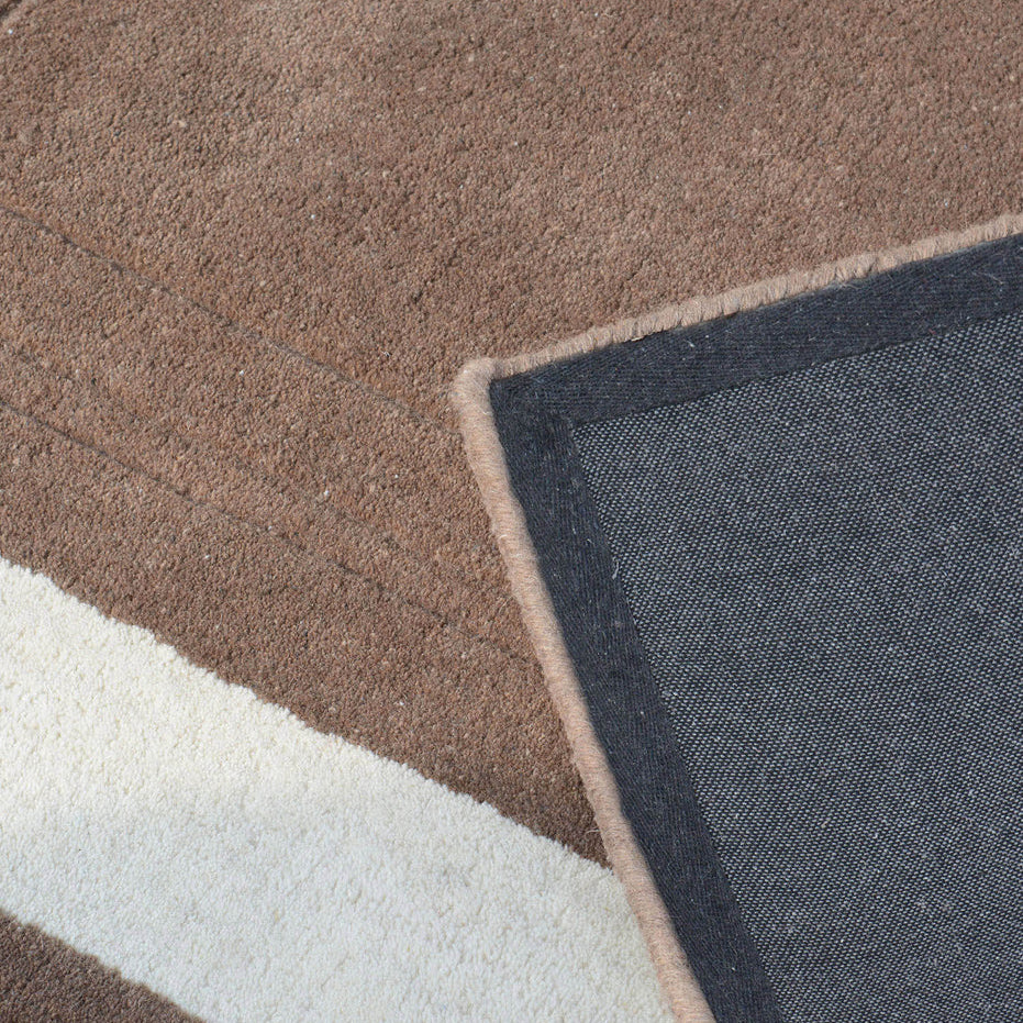 Close-up of a textured rug with geometric pattern in brown, white, and blue.