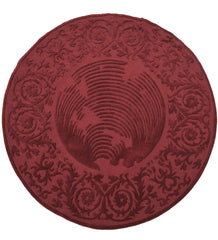 Round burgundy hand-tufted wool rug with embossed floral design