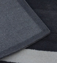 Minimalist charcoal and ivory rug with embossed rectangle detail