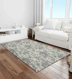 Modern living room with a charcoal patterned rug on wooden floor, white sofa, and minimalist decor