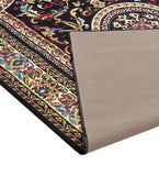 Handwoven classic burgundy rug with intricate floral and geometric patterns, folded to show textured beige backing