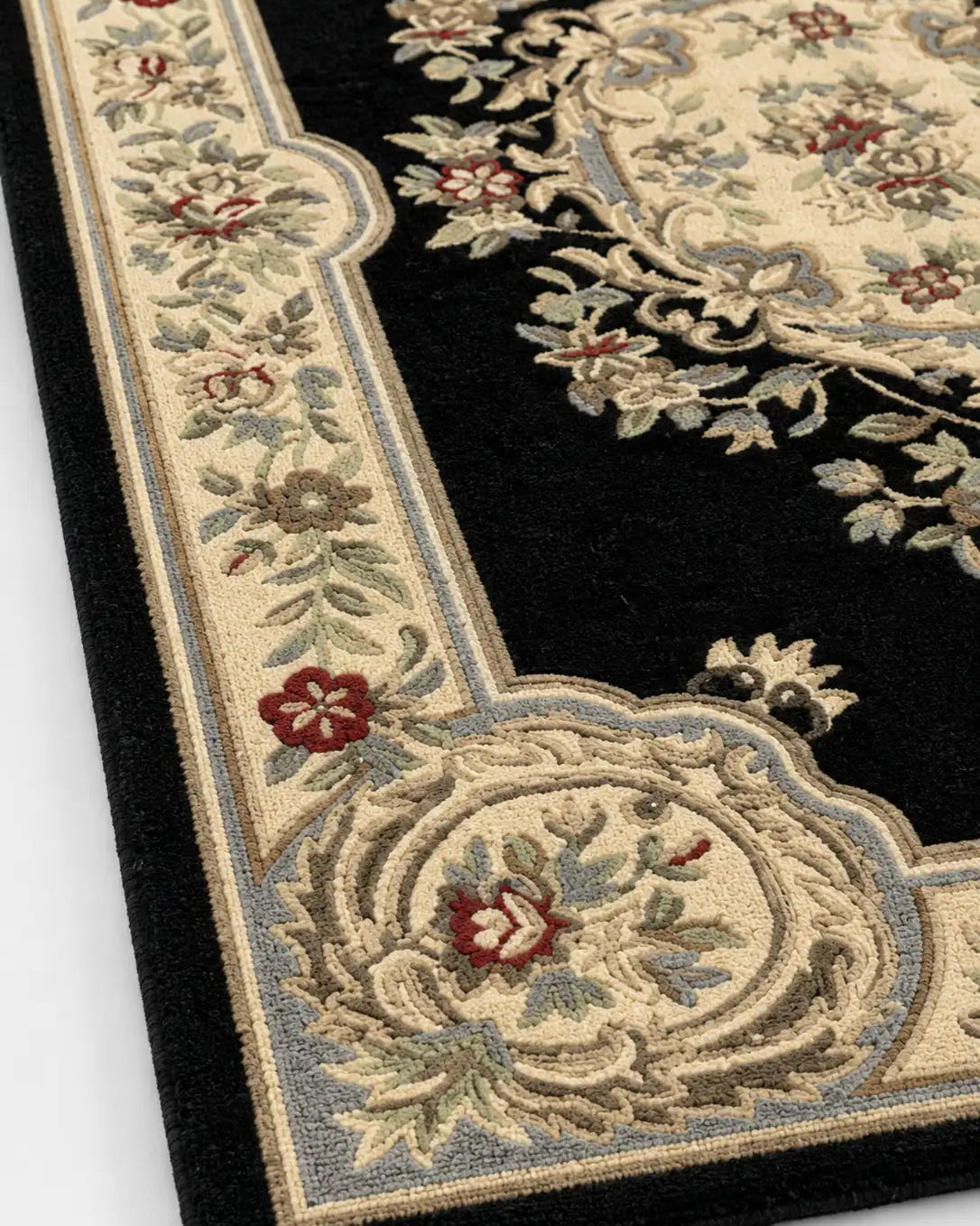 Close-up of an ornate rug with floral patterns on a black background