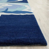 Hand-tufted Coastal Drift rug with abstract blue and white design on light wooden floor by Mannat Rugs