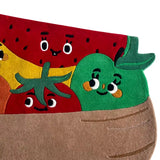 Colorful handwoven rug with smiling fruit characters including watermelon, apple, tomato in a brown basket