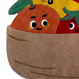 Colorful handwoven rug from Mannat Rugs featuring smiling cartoon fruit characters in a basket