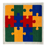 Colorful handwoven puzzle piece rug with red, blue, yellow, and green sections framed by a white border