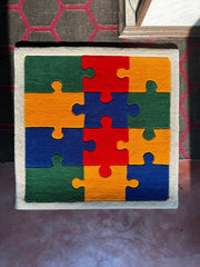 Colorful puzzle piece design on a square frame rug can be placed anywhere like creative spaces or kids room