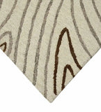 Close-up of a hand-tufted cream rug with taupe and brown abstract line patterns from Mannat Rugs