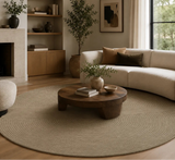 Cozy living room with a fireplace, round wooden coffee table, and beige sectional sofa.