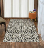 Cream geometric and floral patterned luxury rug on wooden floor in bright room with orange stool