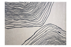 Modern cream rug with bold black artistic pattern.