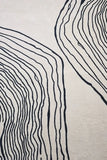 Hand-tufted wool rug in cream and black minimalist style.